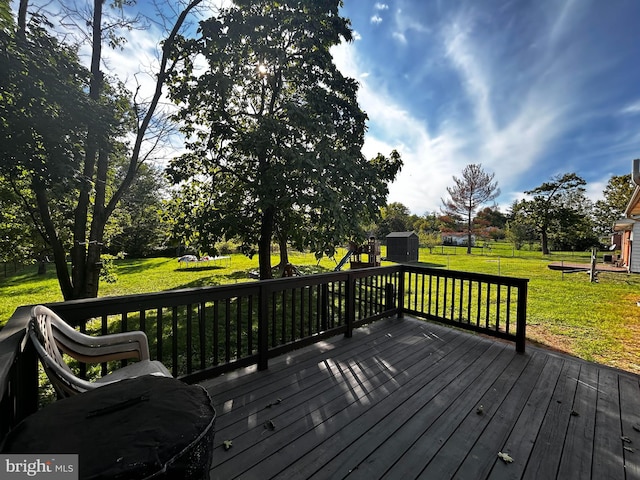 deck with an outdoor structure, a yard, and a storage shed