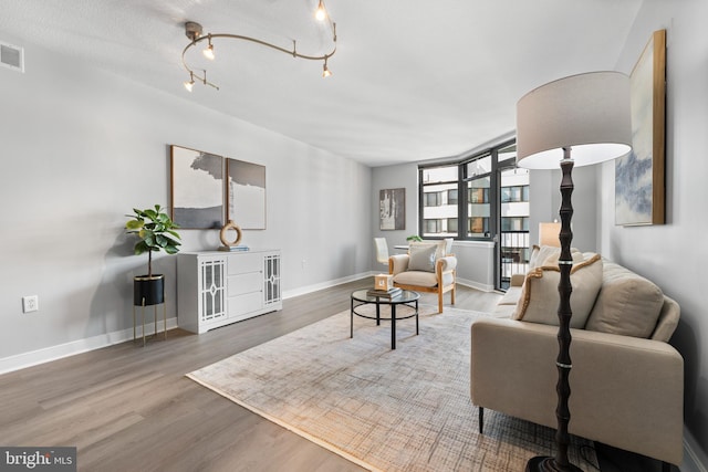 living room with track lighting, wood-type flooring, and a textured ceiling