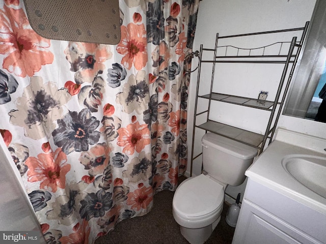 bathroom featuring toilet, vanity, and walk in shower