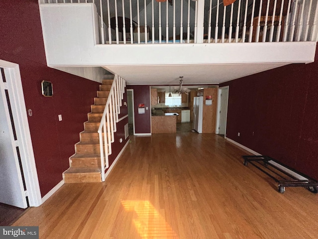 foyer entrance with a towering ceiling and wood-type flooring