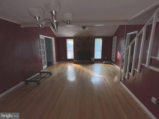 foyer entrance featuring lofted ceiling, hardwood / wood-style flooring, a textured ceiling, and a fireplace