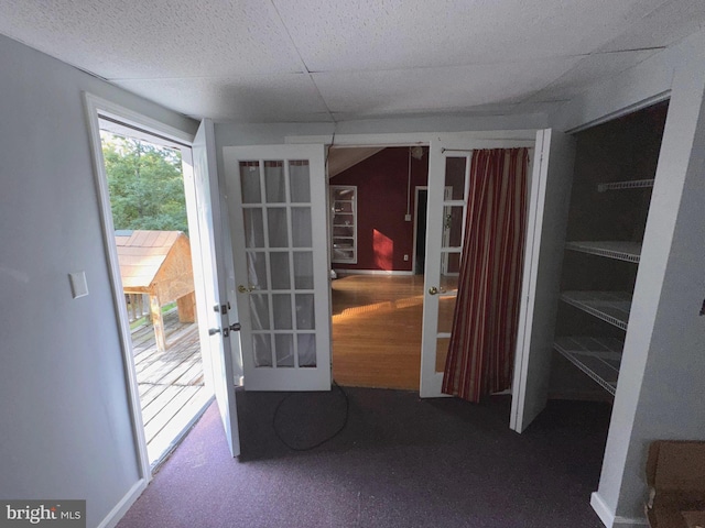 interior space featuring french doors, a paneled ceiling, and carpet flooring