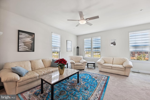 carpeted living room with a ceiling fan, a wealth of natural light, and visible vents