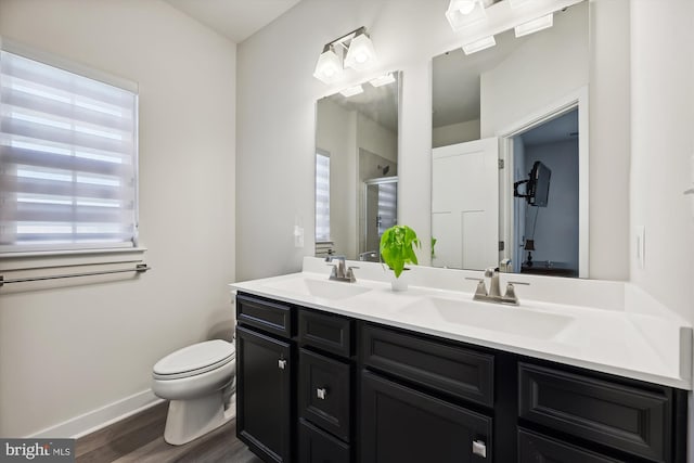 bathroom featuring a shower with shower door, vanity, hardwood / wood-style floors, and toilet