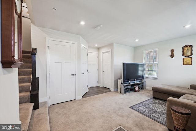 carpeted living area featuring baseboards, stairway, and recessed lighting