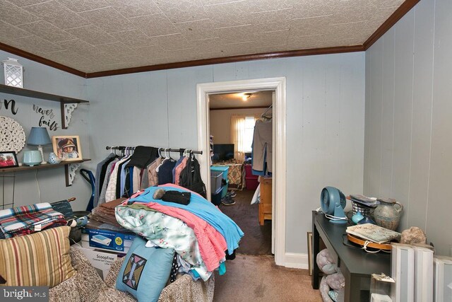 carpeted bedroom featuring crown molding and wood walls