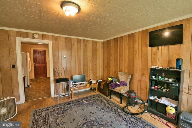 interior space with crown molding, wood walls, and hardwood / wood-style flooring