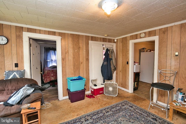 miscellaneous room with ornamental molding, wooden walls, and wood-type flooring