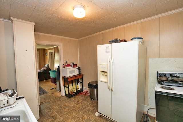 kitchen featuring wooden walls, crown molding, and white appliances