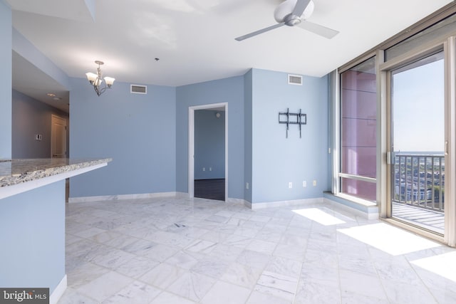 unfurnished living room with ceiling fan with notable chandelier and light tile patterned flooring