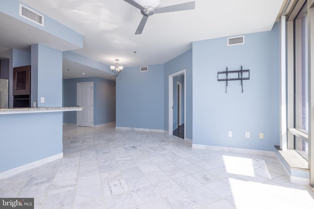 tiled empty room with ceiling fan with notable chandelier