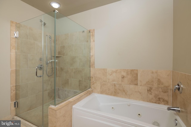 full bath featuring a jetted tub and a shower stall