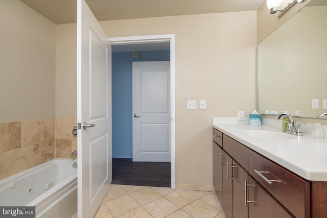 bathroom with baseboards, vanity, a whirlpool tub, and tile patterned floors