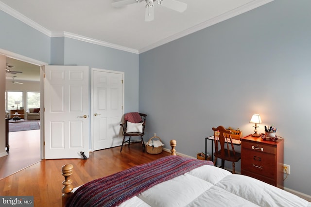 bedroom featuring ornamental molding, dark wood-type flooring, and ceiling fan