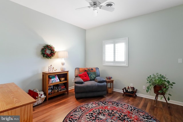 living area featuring ceiling fan and dark hardwood / wood-style floors