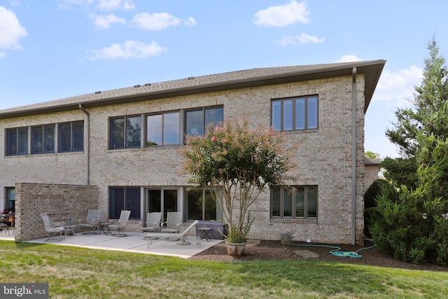 rear view of property with a lawn and a patio