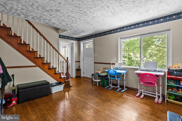 interior space with a textured ceiling and hardwood / wood-style floors