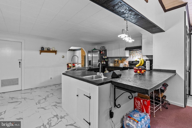 kitchen featuring pendant lighting, stainless steel refrigerator with ice dispenser, white cabinets, sink, and kitchen peninsula