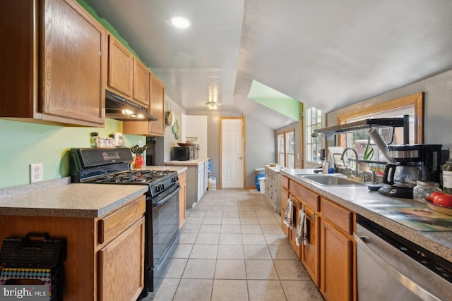 kitchen featuring black gas range, vaulted ceiling, stainless steel dishwasher, under cabinet range hood, and a sink