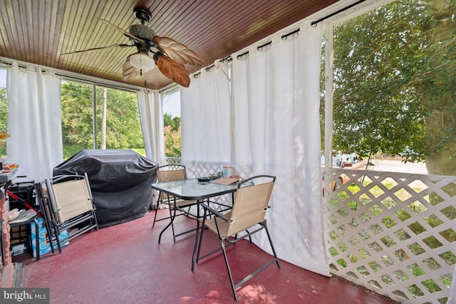 sunroom featuring wooden ceiling and a ceiling fan