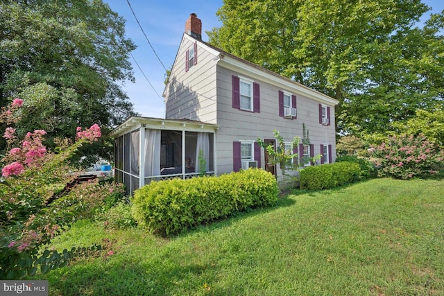 back of house featuring a sunroom and a yard