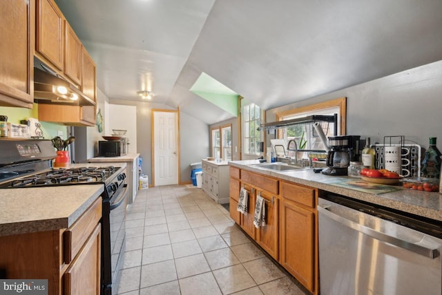 kitchen with light countertops, gas stove, vaulted ceiling, dishwasher, and under cabinet range hood