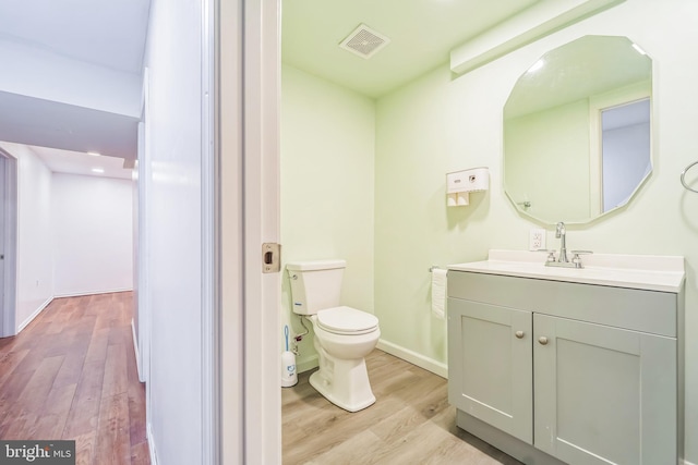 bathroom featuring toilet, hardwood / wood-style flooring, and vanity