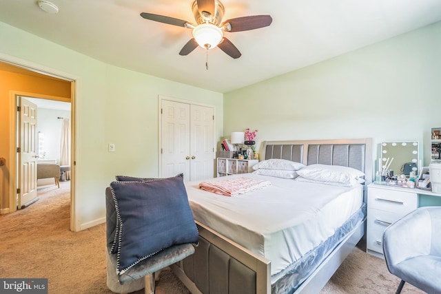 bedroom with a closet, ceiling fan, and light colored carpet