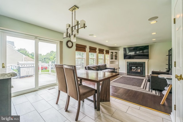 dining area featuring a premium fireplace and light hardwood / wood-style flooring