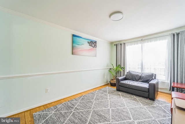 living area featuring crown molding and wood-type flooring