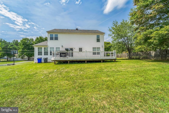 back of house with a lawn and a wooden deck