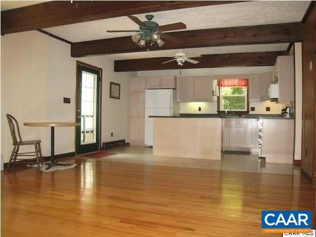 kitchen with white appliances, ceiling fan, light hardwood / wood-style floors, and beamed ceiling