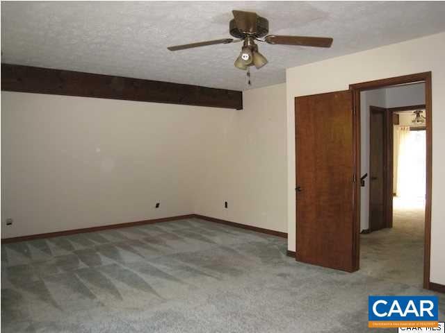 unfurnished bedroom with ceiling fan, a textured ceiling, and carpet