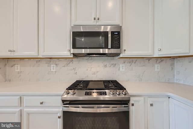 kitchen featuring decorative backsplash, appliances with stainless steel finishes, white cabinetry, and light countertops