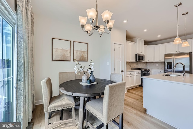 dining room featuring light wood-type flooring, recessed lighting, and a chandelier