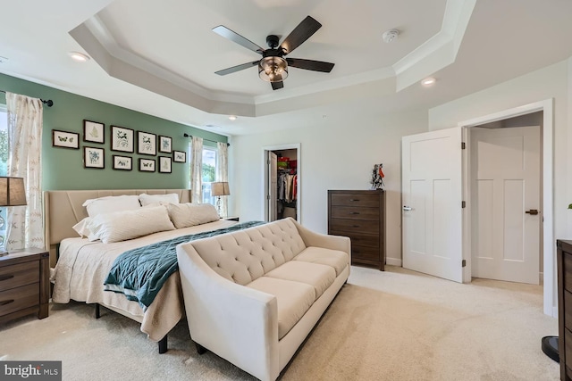 bedroom featuring crown molding, a closet, a walk in closet, a tray ceiling, and recessed lighting