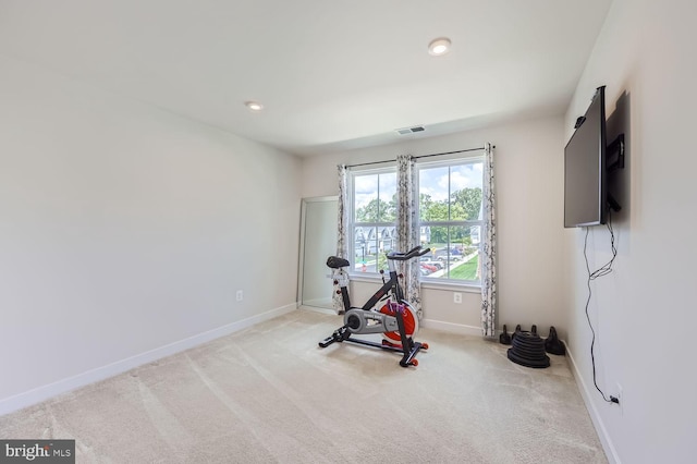 workout room with baseboards, visible vents, and carpet
