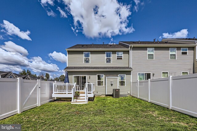 back of house featuring a yard, a fenced backyard, and a deck
