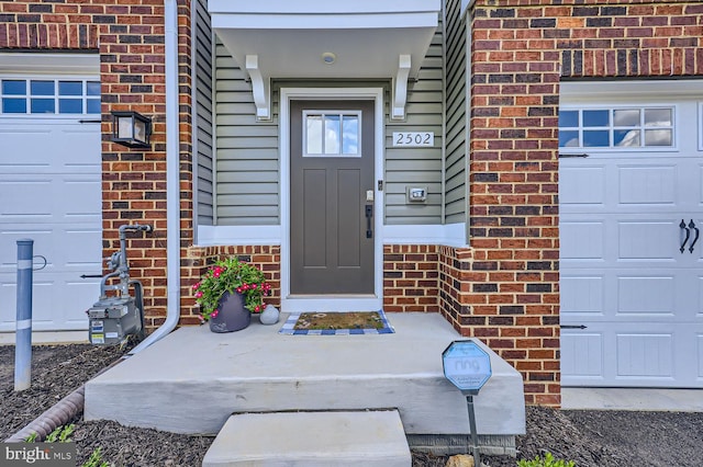 property entrance featuring brick siding and a garage