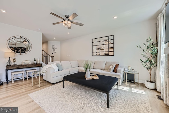 living area with light wood-style flooring, recessed lighting, stairway, and a ceiling fan