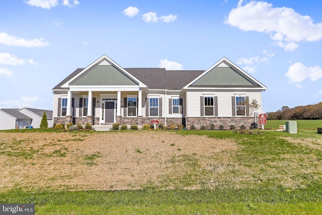 craftsman inspired home featuring a front yard and covered porch