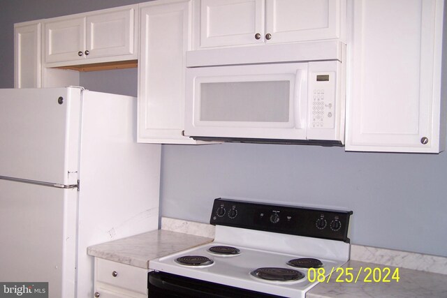 kitchen with white appliances and white cabinets