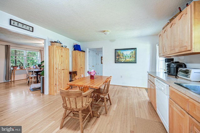 kitchen featuring a textured ceiling, light brown cabinetry, white dishwasher, and light hardwood / wood-style floors