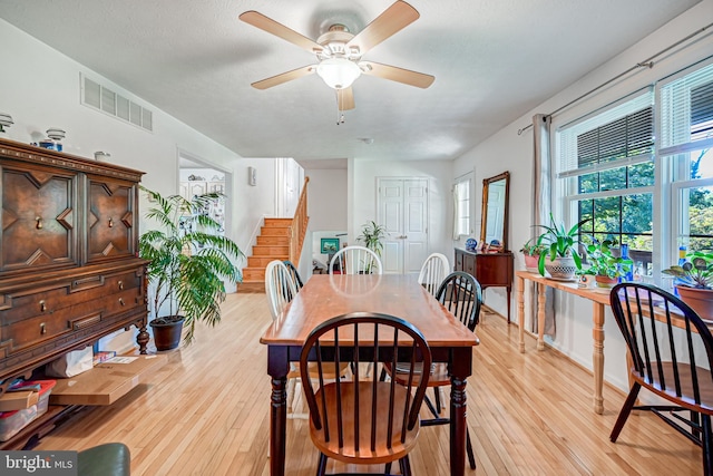 dining space featuring a textured ceiling, light hardwood / wood-style flooring, and ceiling fan