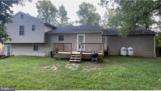 back of house featuring a lawn and a wooden deck