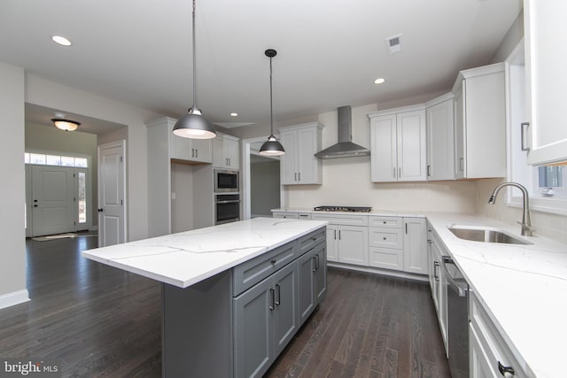 kitchen featuring sink, dark hardwood / wood-style flooring, stainless steel appliances, wall chimney range hood, and white cabinets