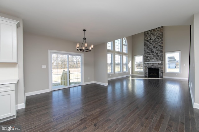 unfurnished living room with a fireplace, plenty of natural light, and dark hardwood / wood-style floors