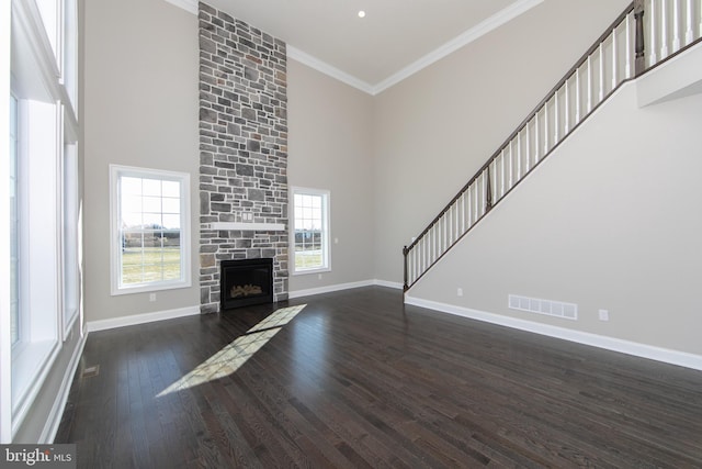 unfurnished living room featuring a high ceiling, dark hardwood / wood-style flooring, and a fireplace