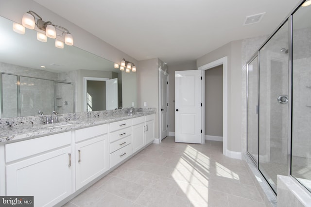 bathroom featuring tile patterned floors, an enclosed shower, and vanity