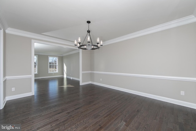 empty room featuring dark hardwood / wood-style flooring, an inviting chandelier, and ornamental molding